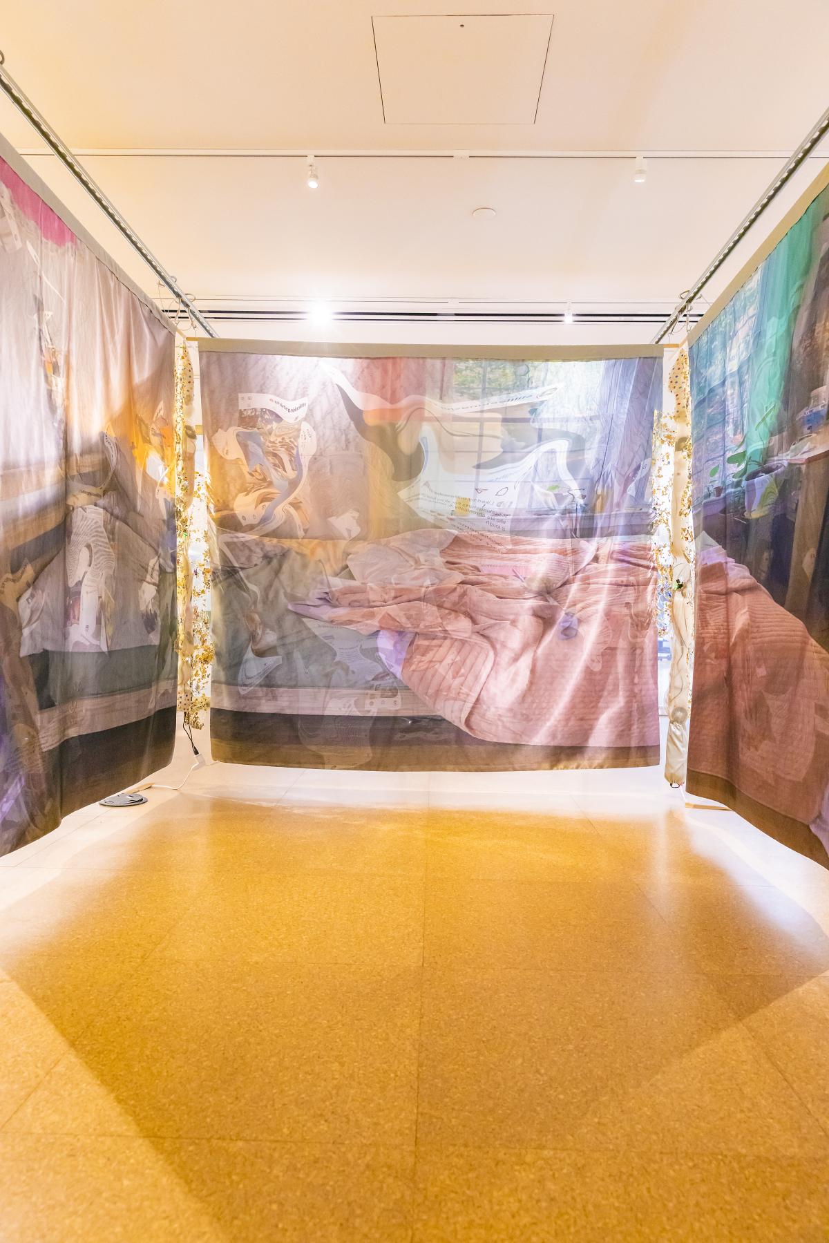 Art installation as viewed from head on, showing the main center panel and the display of the artists' bed.